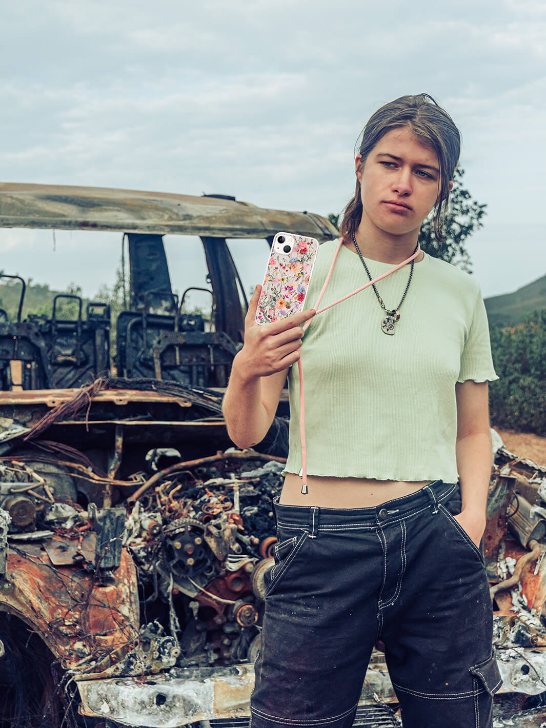 Holding crossbody case The Fig Olive Garden infront of car wreck